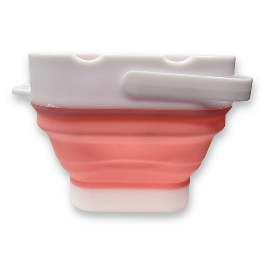 Pink SillyFarm Pop n Go Collapsible Water Cup with flexible silicone body, folding carry handle, and built-in brush rests. Holds up to 16 oz and folds flat for storage.