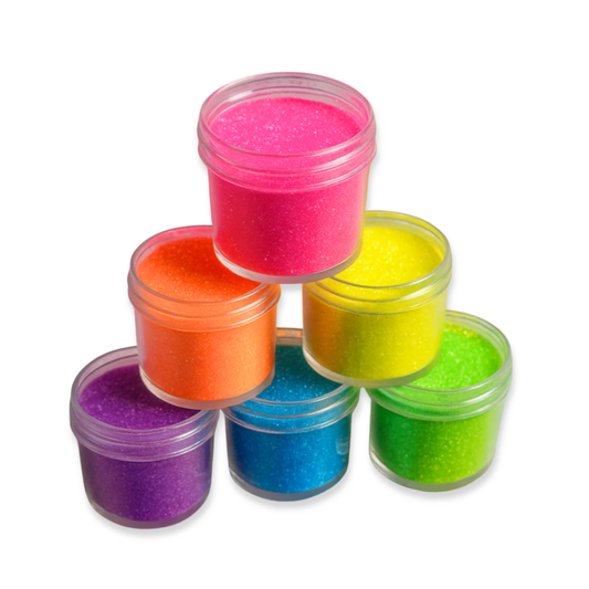 Six small clear plastic jars filled with glittery in assorted bright colors, arranged in a pyramid stack on a white background. The colors visible are pink, orange, yellow, blue, green, and purple.
