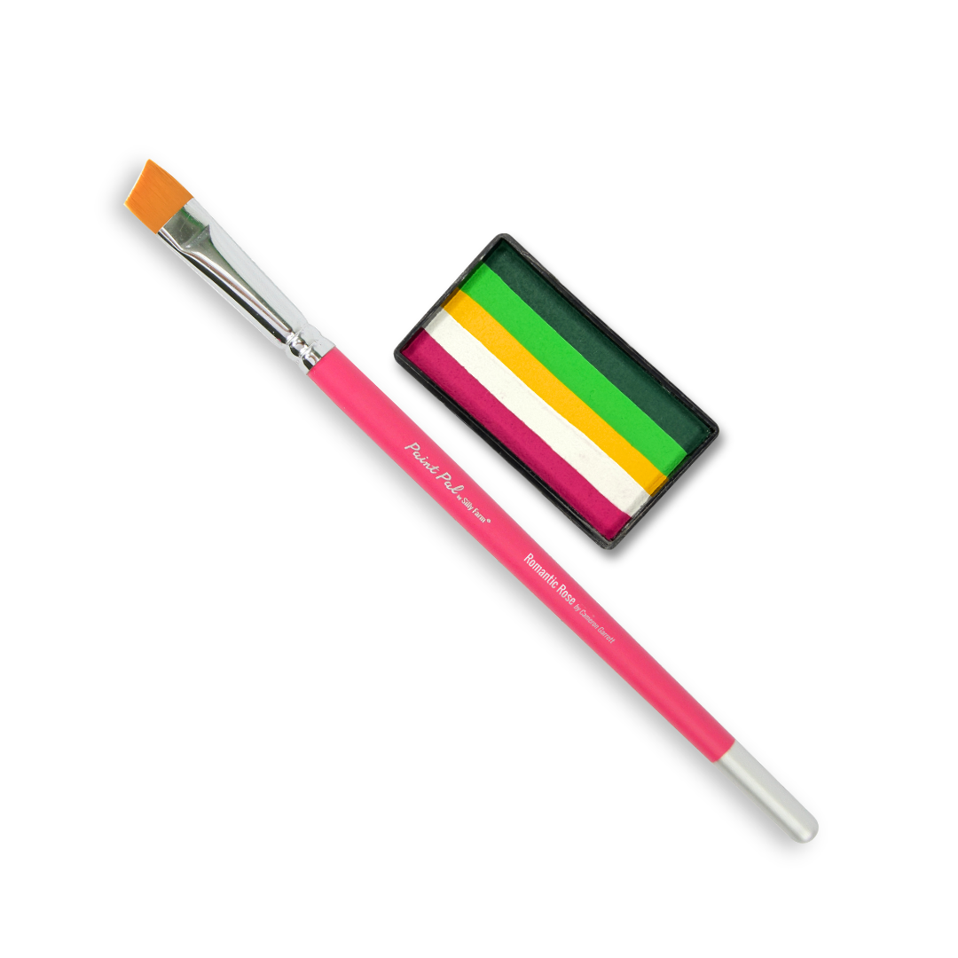 A pink-handled paint brush with a triangular orange bristle tip shown next to a small black palette containing green, yellow, white, and pink paint stripes. The brush has white text reading 'Angel Pink Limelight' and 'Premium Soft Brush'.