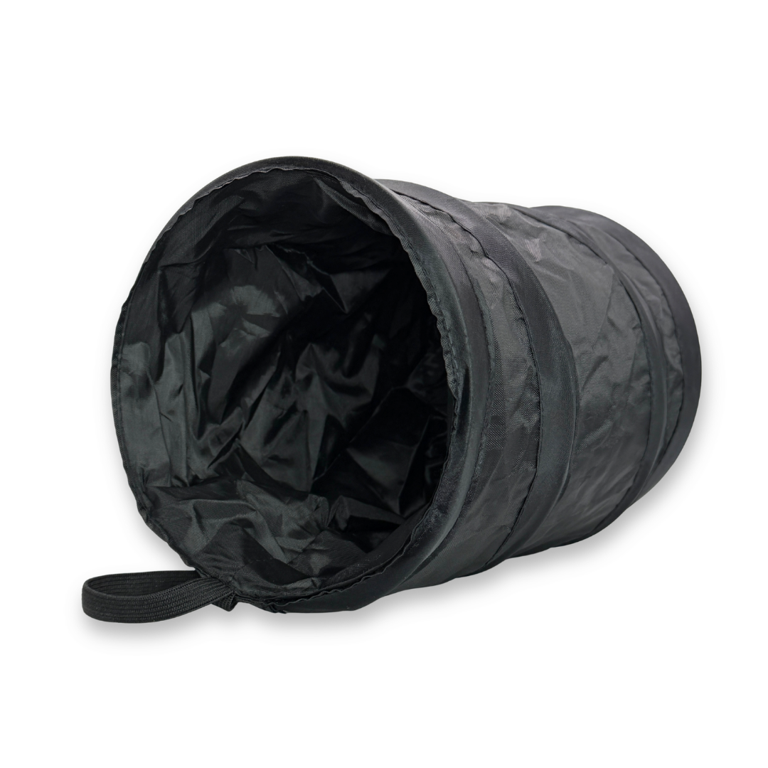 Black collapsible pop-up tabletop trash can with waterproof interior and hanging loop for face painting and makeup workstations.