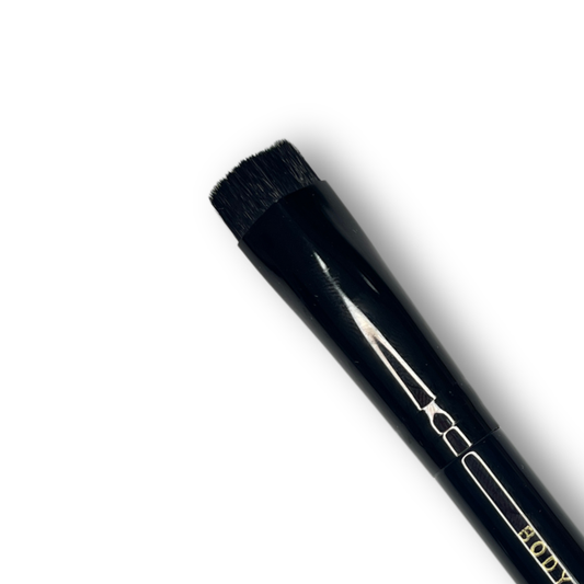 Close up of Body Color Cosmetics Diamond Kabuki Stiletto face painting brush with black angled bristles designed for precision stencil application.