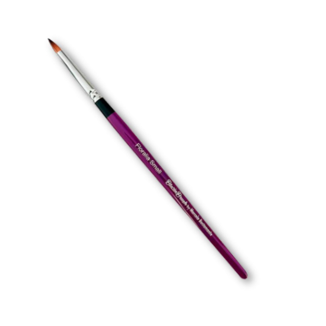 Blazin Floralia Small Petal Round Brush by Marcela Bustamante with a purple handle, silver ferrule, and pointed bristles.