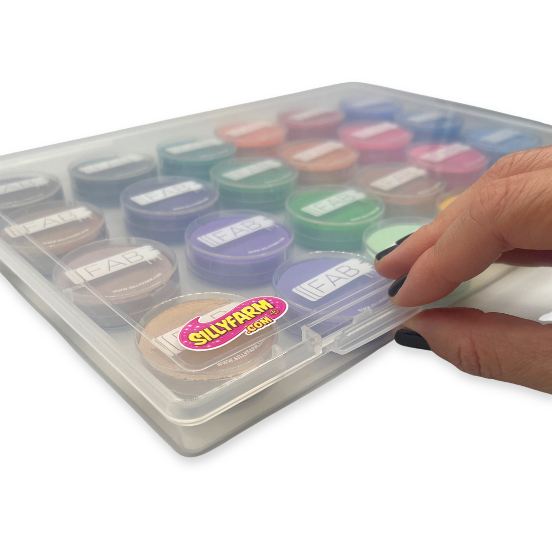 Hand holding the latch closure of a transparent container with colorful face paint container 'Silly Farm' branding.