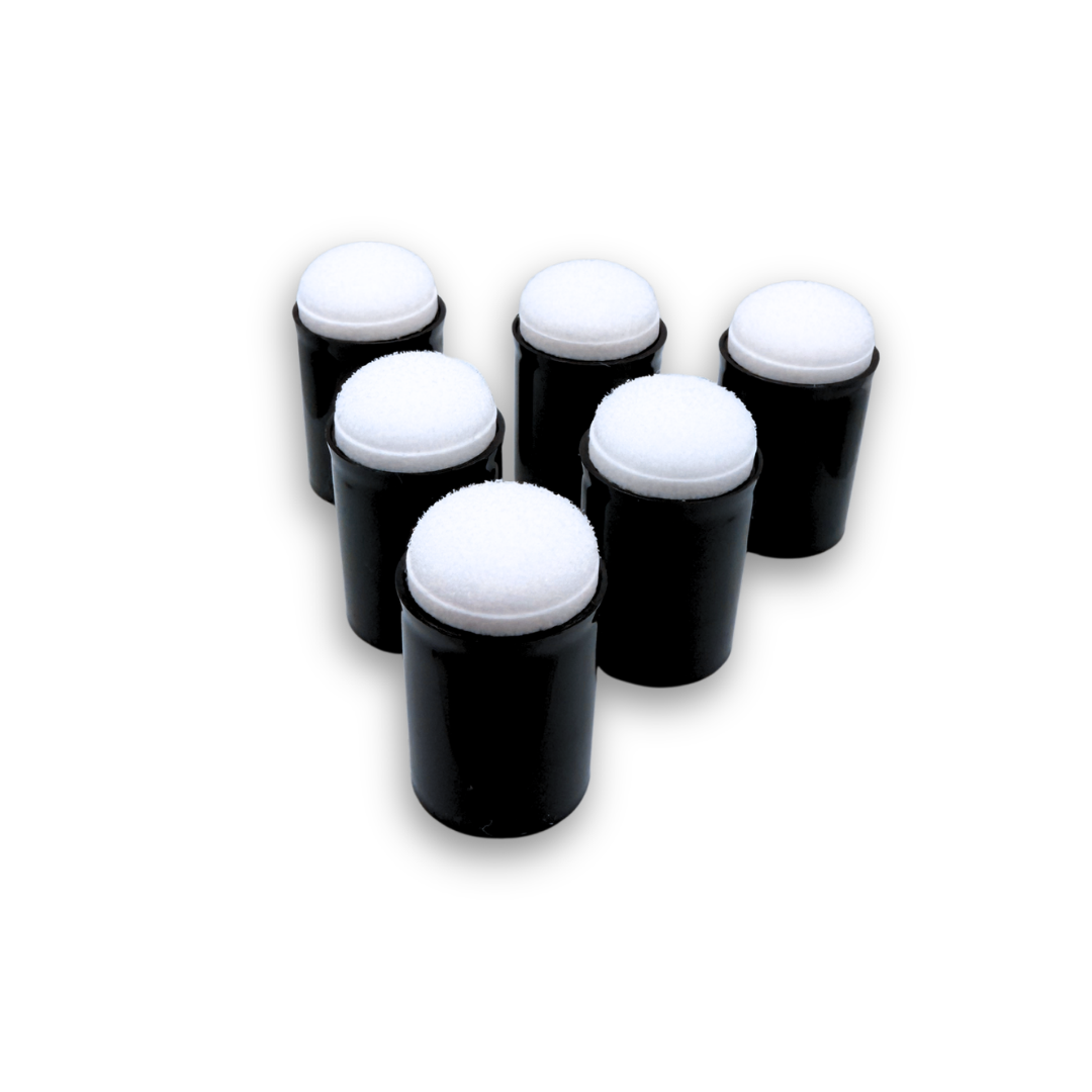 Five black cylindrical finger daubers with white circular foam tops, arranged in a loose cluster on a plain white background.