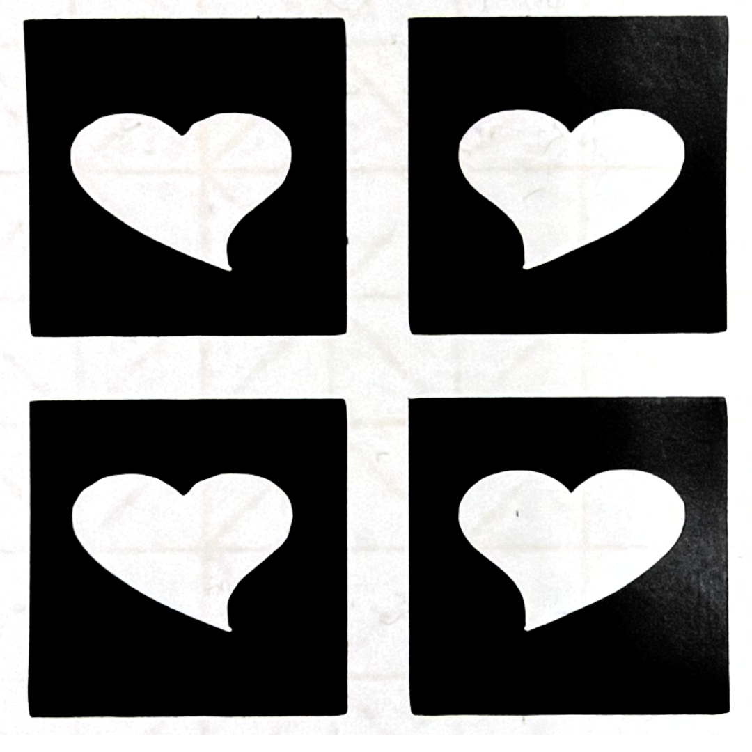 Glitter tattoo stencil featuring four small heart designs with medical-grade adhesive for creating crisp cosmetic glitter tattoos.