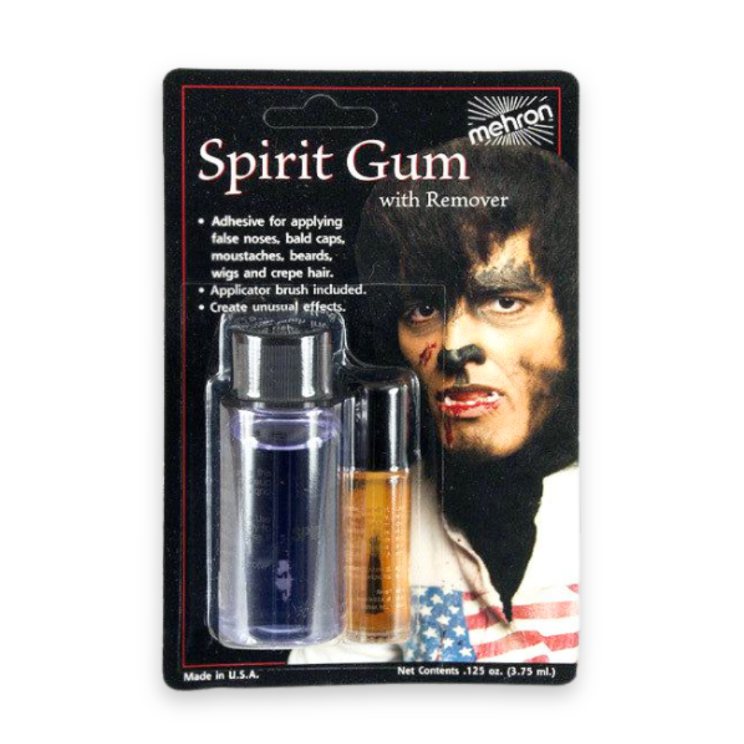 Mehron Spirit Gum with Remover in its original blister card packaging, featuring a small bottle of dark blue spirit gum and an applicator brush with amber liquid, alongside a graphic of a man with face makeup.