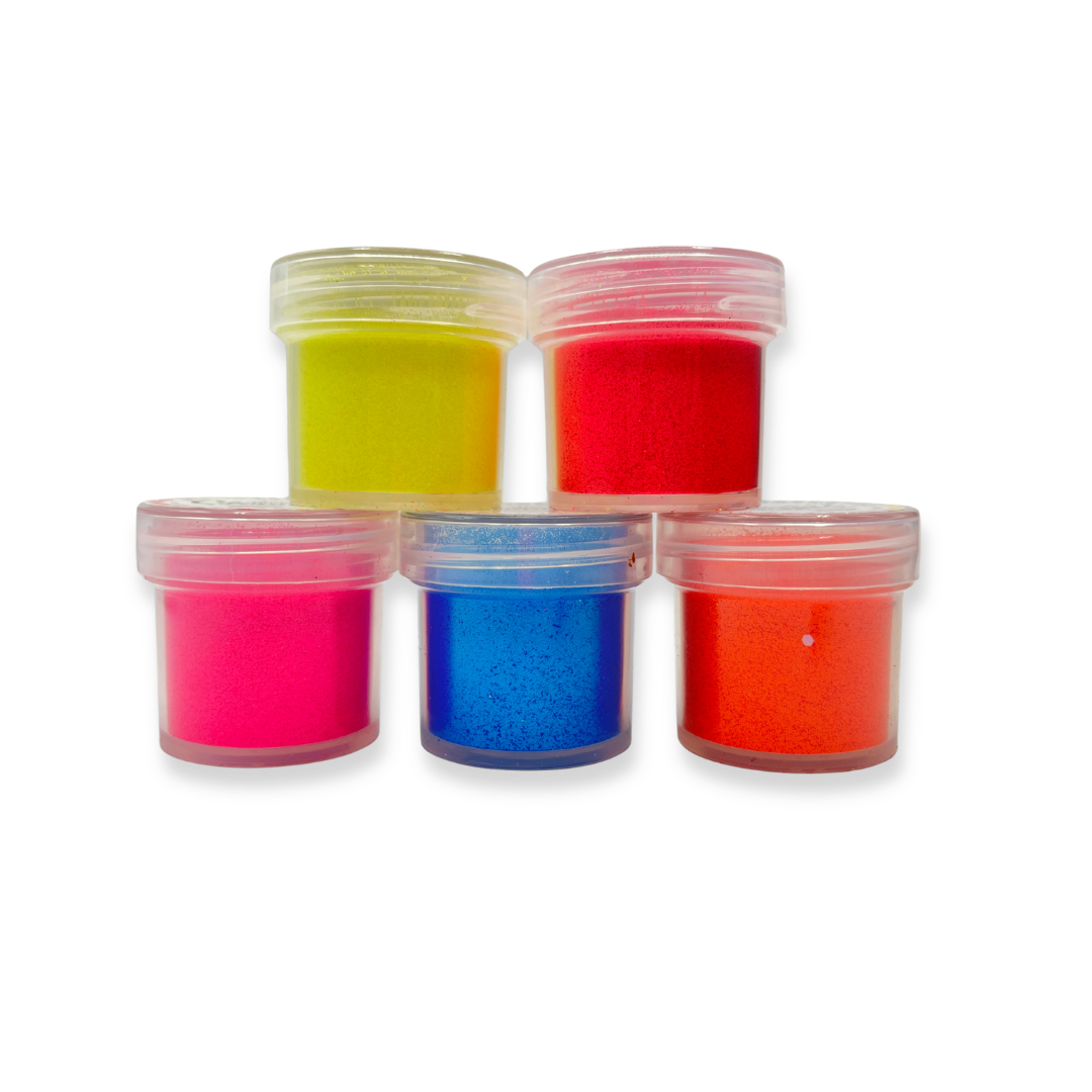 Five small containers of colorful neon glitter in jar containers on a white background
