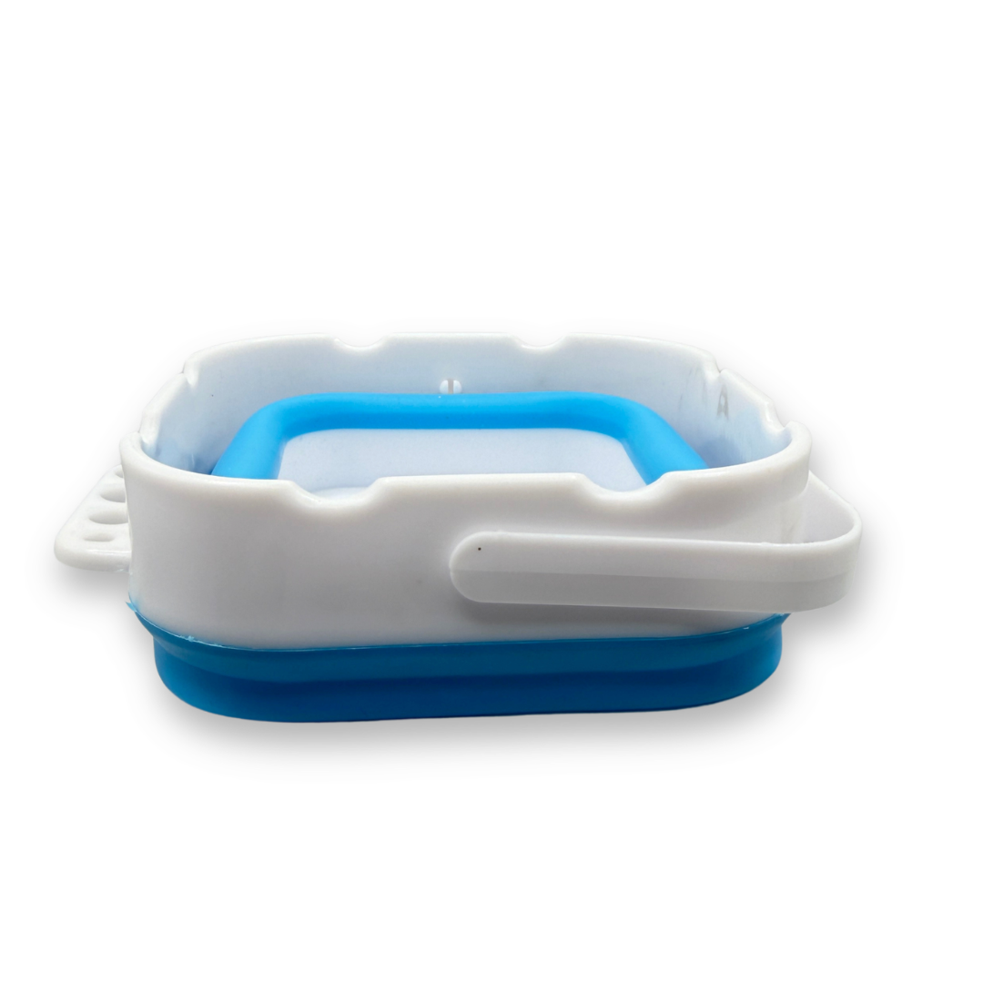 SillyFarm Pop n Go Collapsible Water Cup folded flat in blue and white silicone with a compact square design, built-in brush rests, and folding carry handle for easy storage and travel.