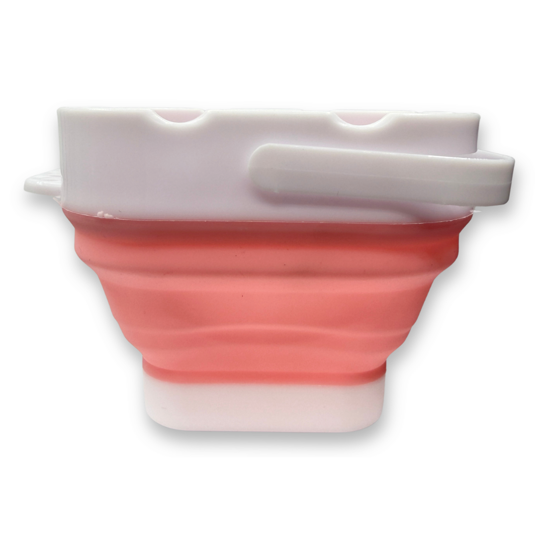 Pink SillyFarm Pop n Go Collapsible Water Cup with flexible silicone body, folding carry handle, and built-in brush rests. Holds up to 16 oz and folds flat for storage.