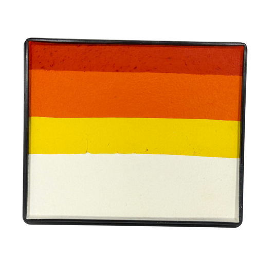 Tiger-inspired Rainbow Cake face paint with layered stripes of white, bright yellow, orange, and reddish-orange in a rectangular container.