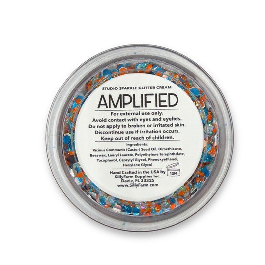 Back view of Amplified Studio Sparkle Glitter Cream in a clear round cosmetic jar showing the product label, ingredients, safety information, and usage details.