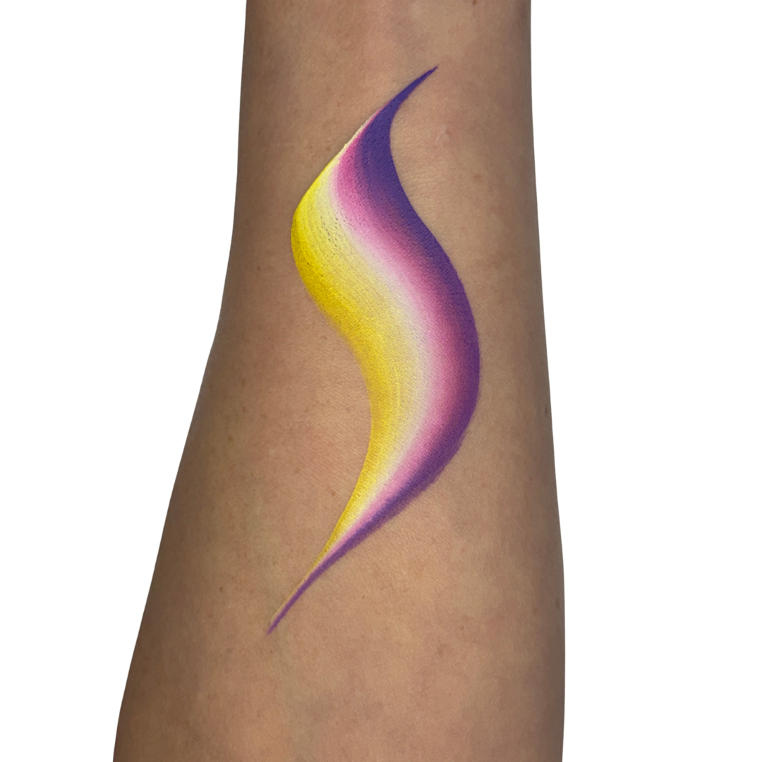 a face paint swatch on skin with yellow, white pink and purple